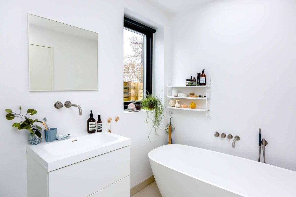 Bathroom Extraction white bath sink cupboards and walls with mirror and window